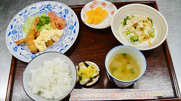 ご飯、エビフライ、付け合わせ、ブロッコリーのサラダ、コンソメスープ、くだもの、漬物
